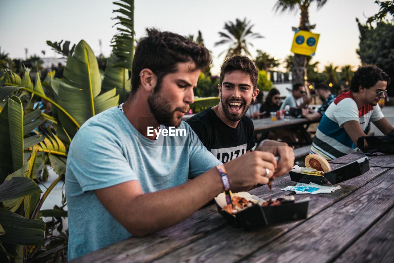 GROUP OF PEOPLE SITTING AT TABLE