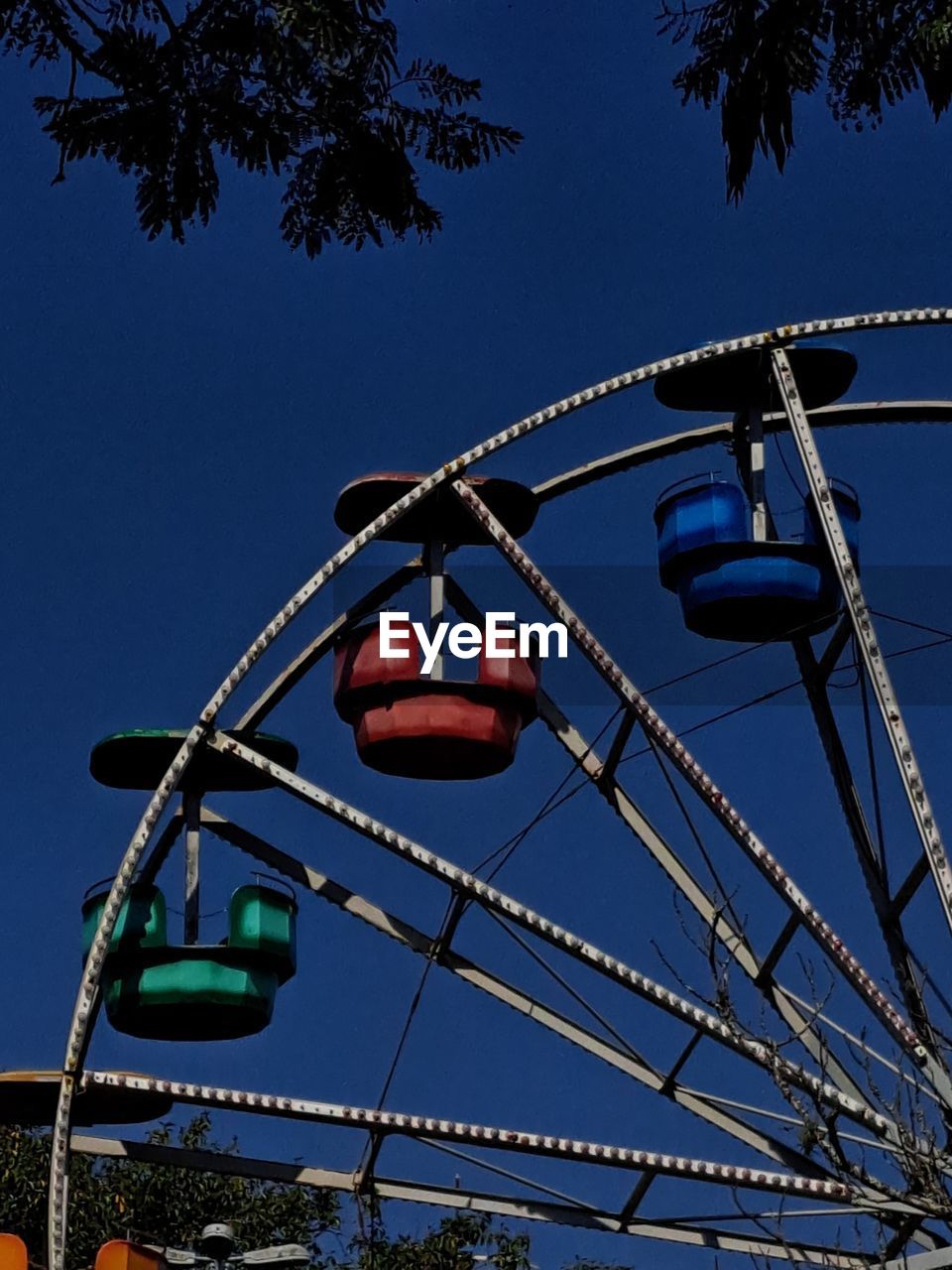 amusement park, amusement park ride, sky, arts culture and entertainment, park, ferris wheel, nature, low angle view, tree, recreation, blue, clear sky, amusement ride, no people, plant, outdoors, architecture, day, built structure, metal, carnival