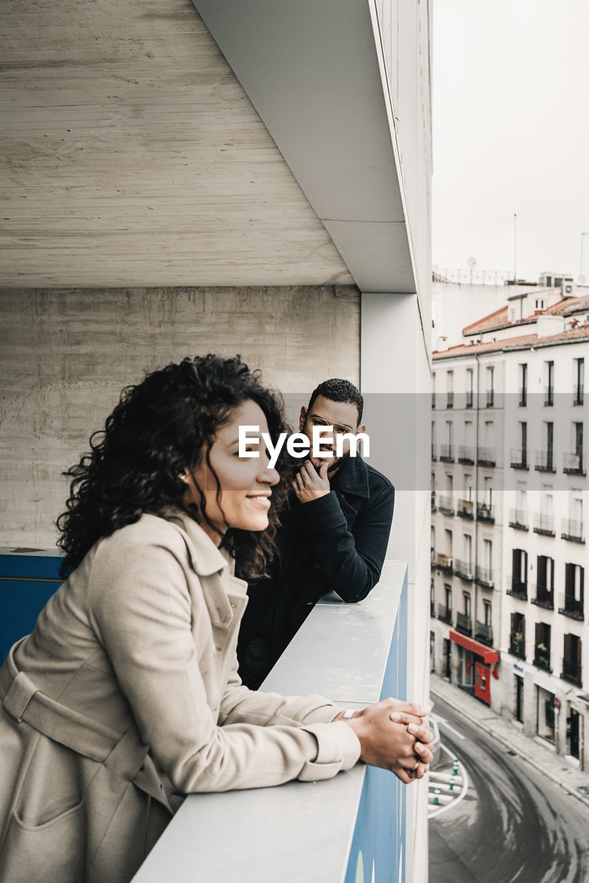 Side view of young couple looking at camera