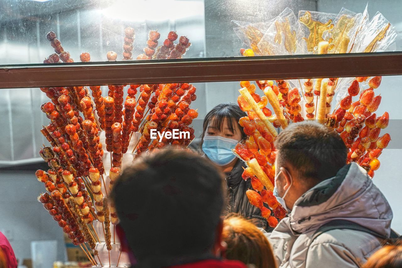 Rear view of people looking at market