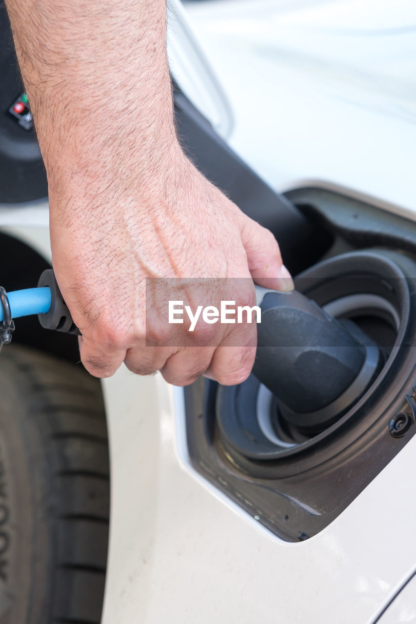 Man hand holding an electric vehicle charging connector