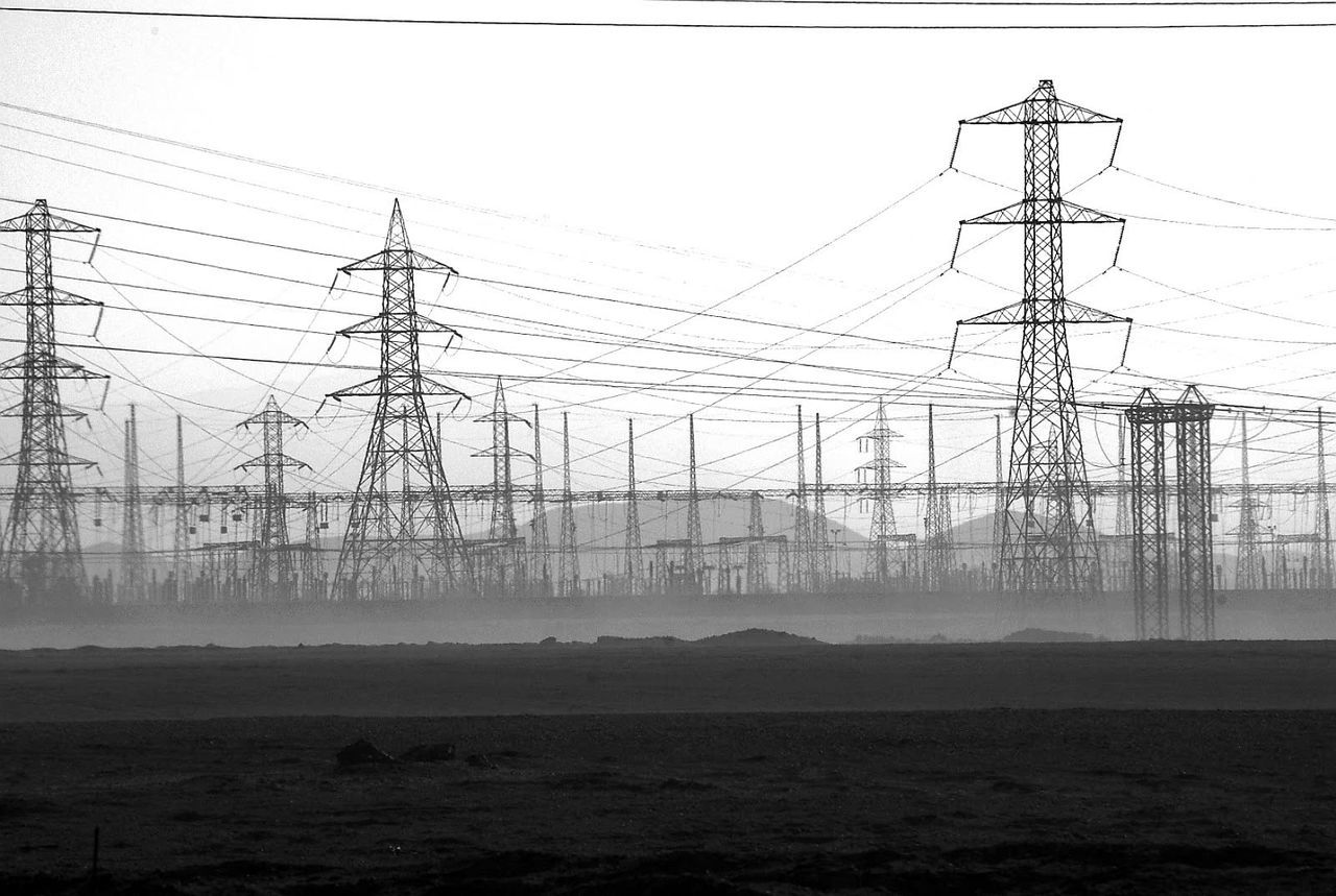 ELECTRICITY PYLON ON FIELD AGAINST SKY IN FOGGY WEATHER
