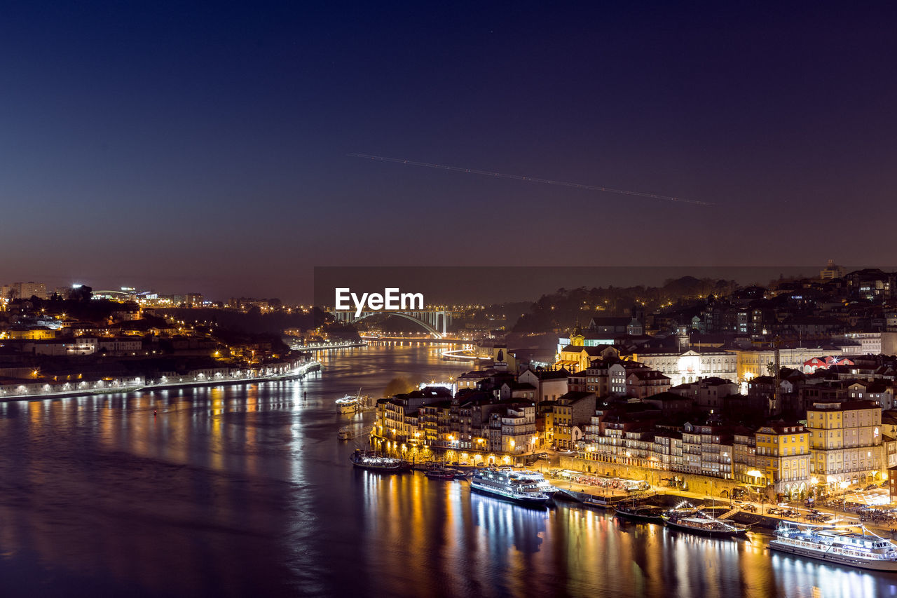 Illuminated cityscape against sky at night