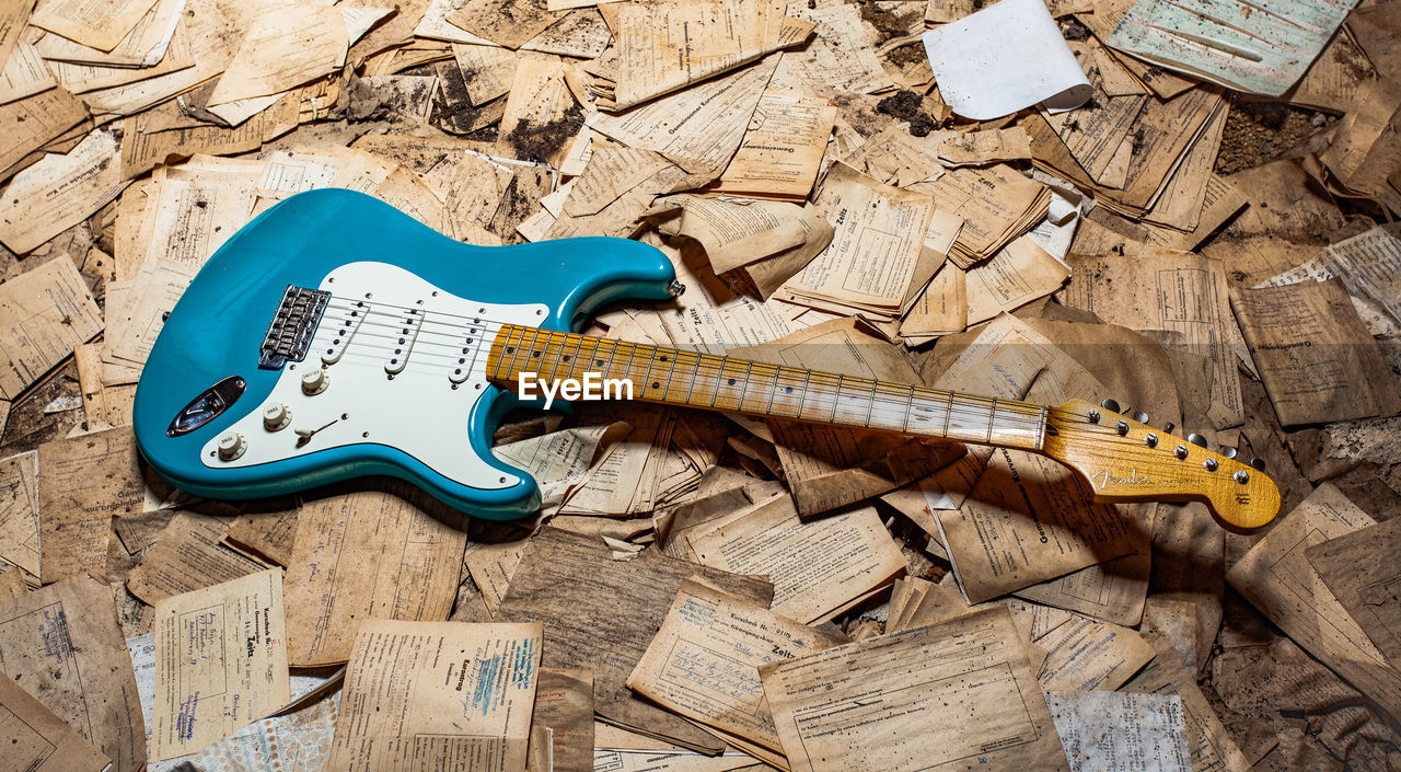 HIGH ANGLE VIEW OF GUITAR ON WOOD