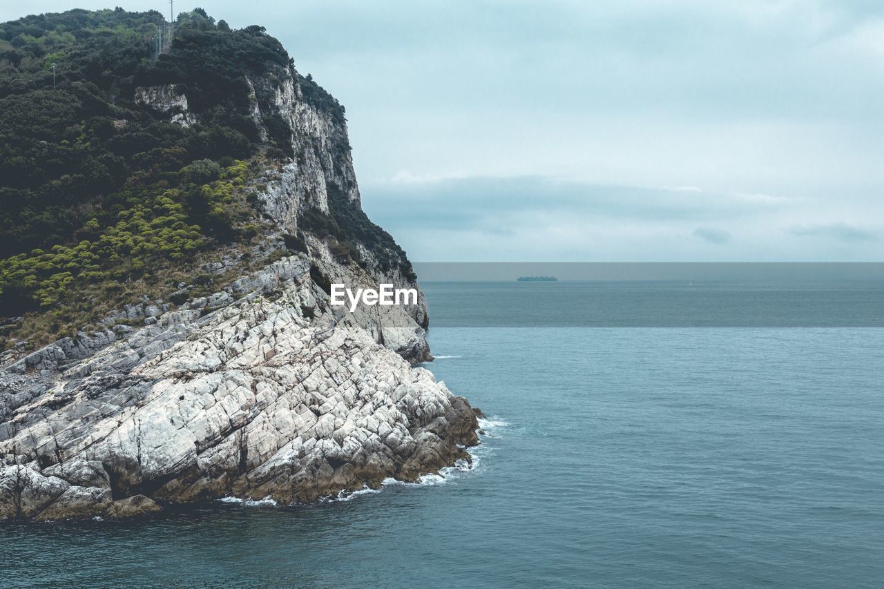 Rock formation in sea against sky