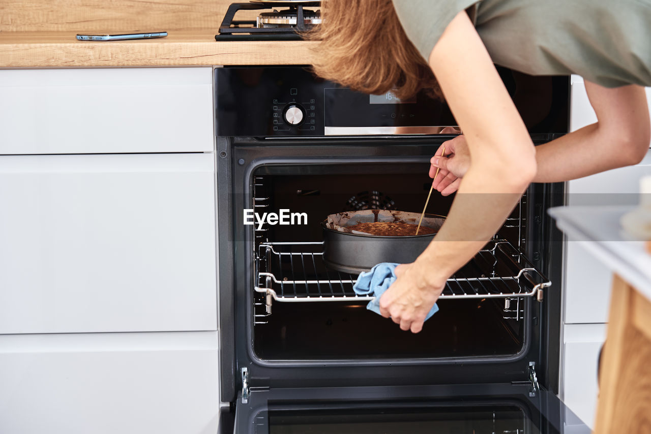 Housewife prepares cake in kitchen. homemade cake baking in oven