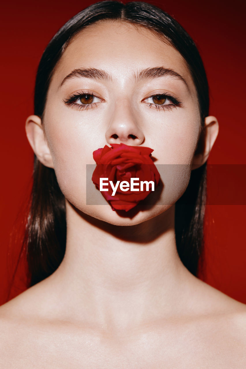 portrait of young woman with eyes closed against yellow background