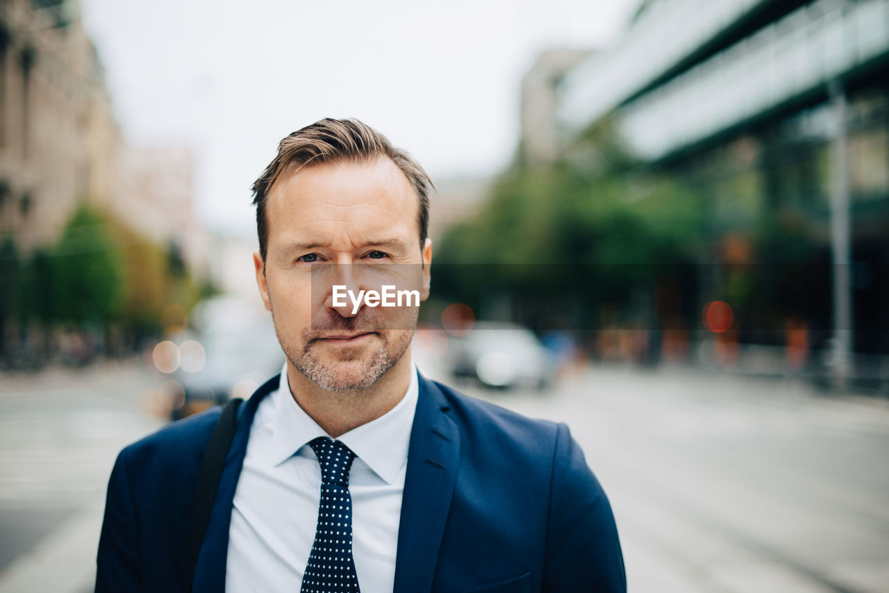 Portrait of confident mature businessman standing in city