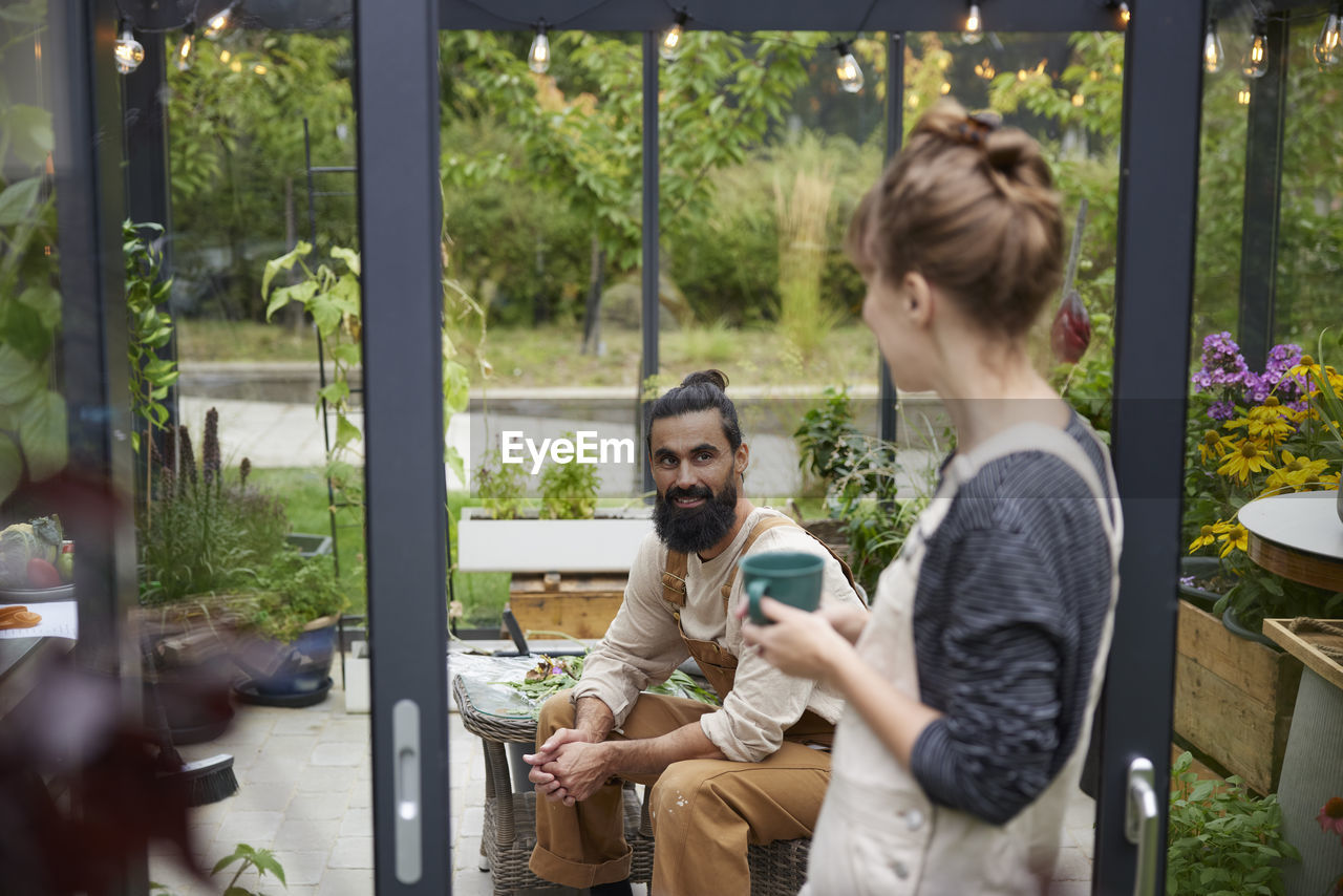 Friends talking in greenhouse