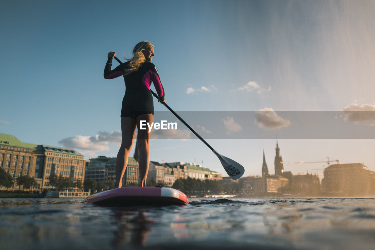 WOMAN STANDING ON BOAT IN CITY