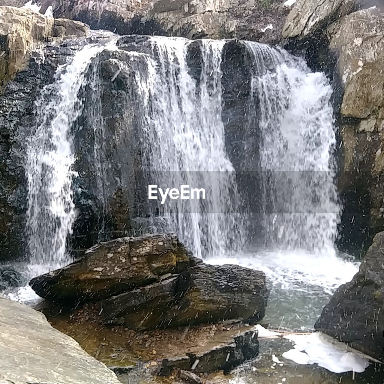 SCENIC VIEW OF WATERFALL IN STREAM
