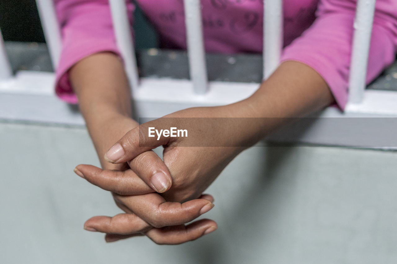 Cropped hands of woman at window