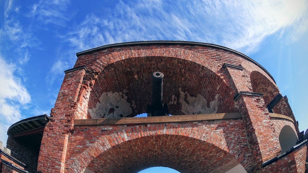 Low angle view of cannon against blue sky