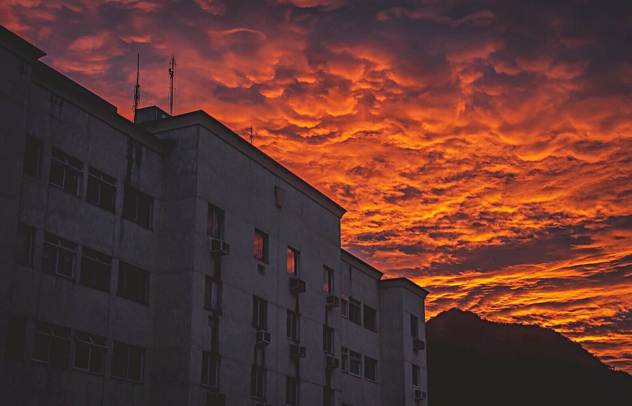 LOW ANGLE VIEW OF BUILDINGS AGAINST CLOUDY SKY