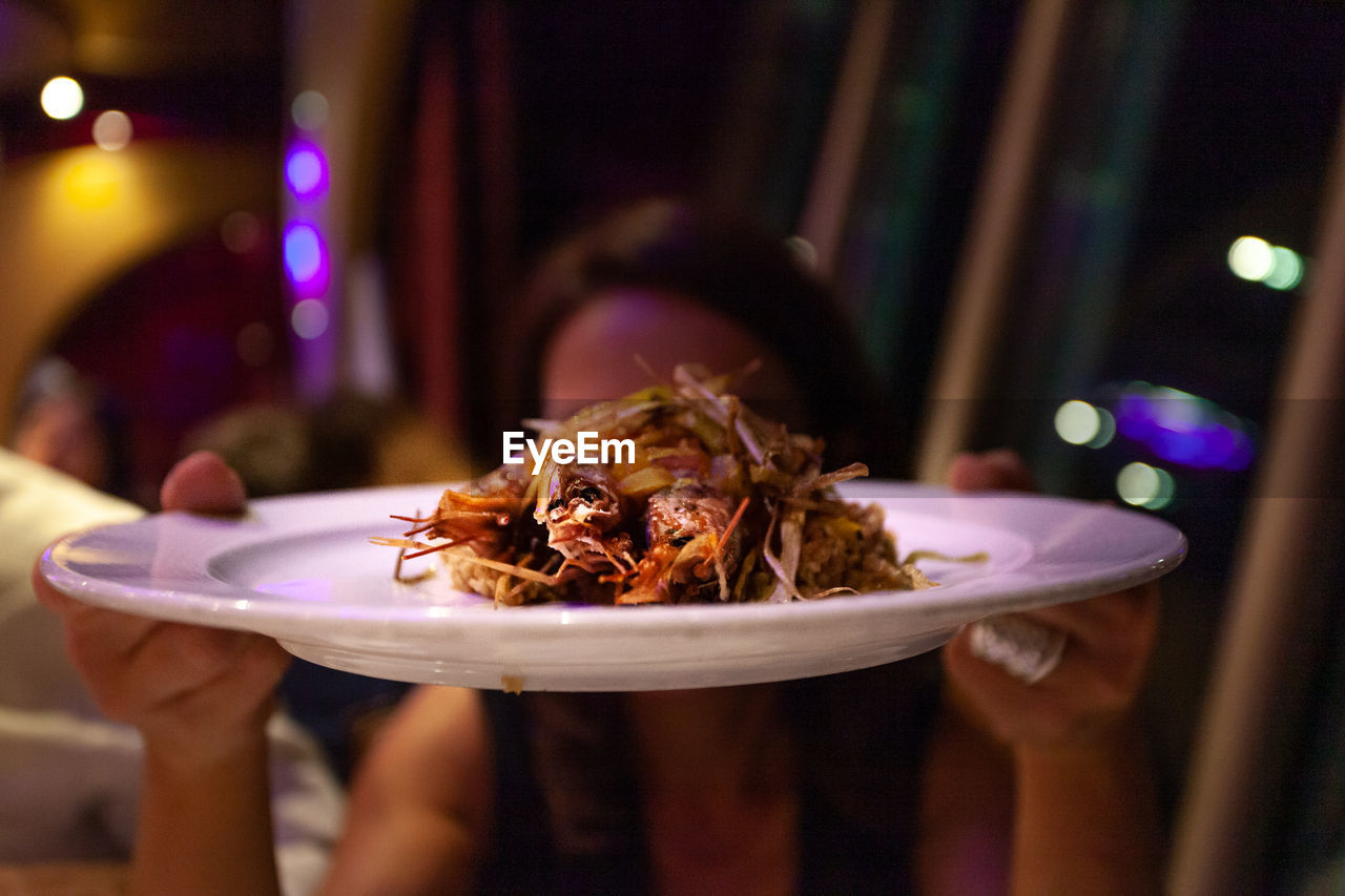 Close-up of woman holding food in plate