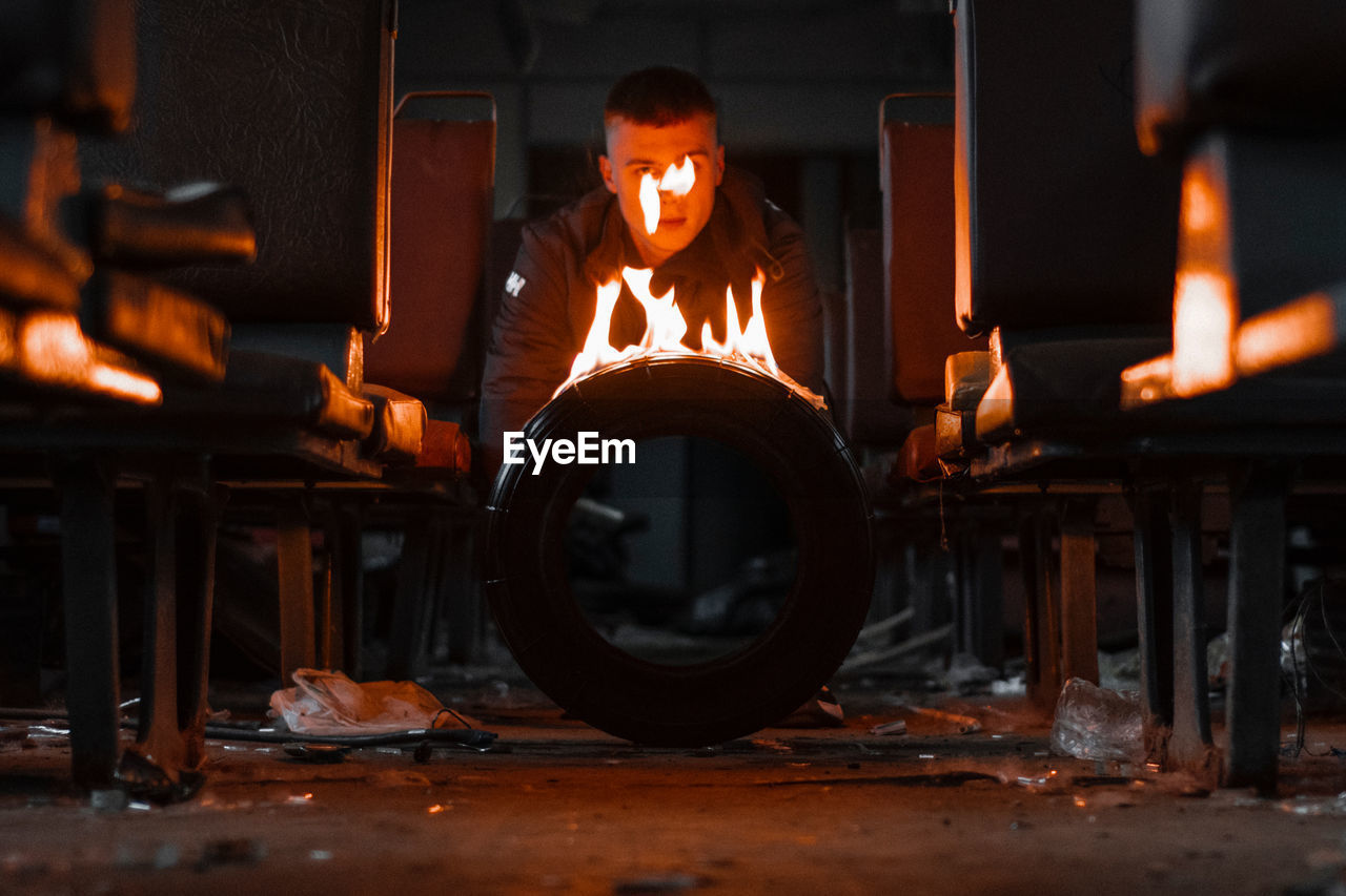 Close-up of burning tire against man in background in train