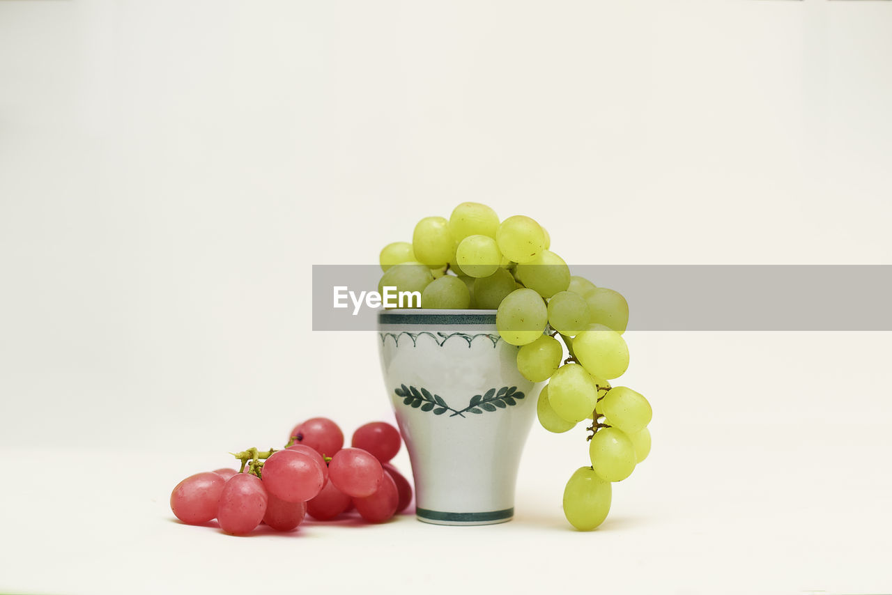 Close-up of grapes over white background