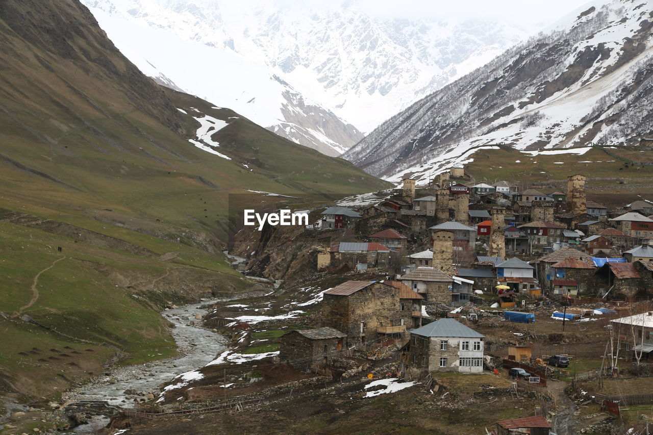 AERIAL VIEW OF BUILDINGS ON SNOWCAPPED MOUNTAIN