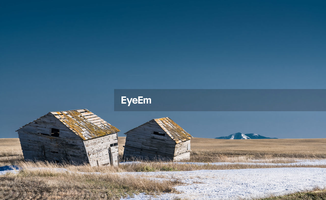 HOUSES ON FIELD AGAINST CLEAR SKY