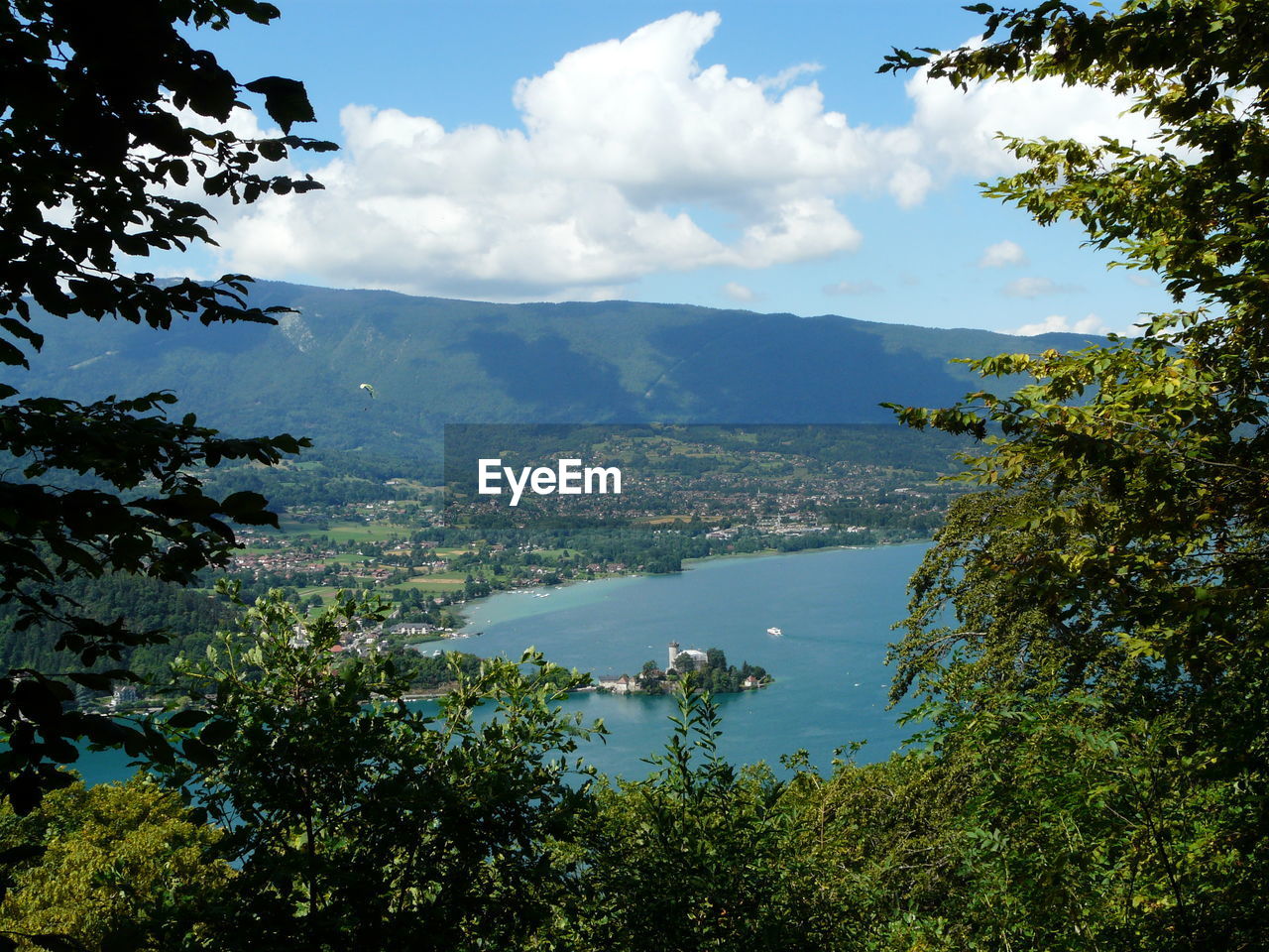 Scenic view of mountains and lake annecy seen through trees