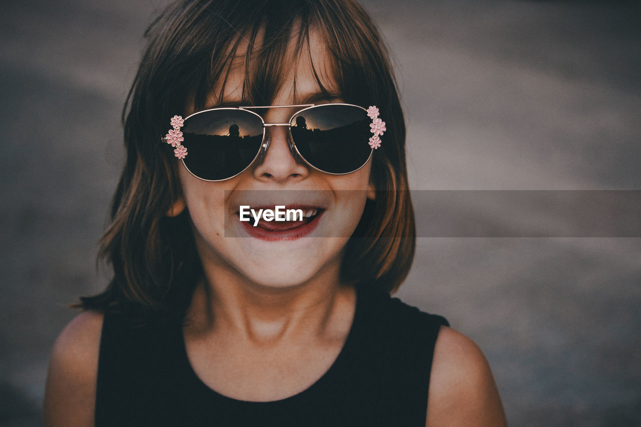 Portrait of smiling cute girl wearing sunglasses