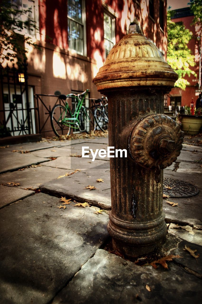 Rusty fire hydrant on street against building