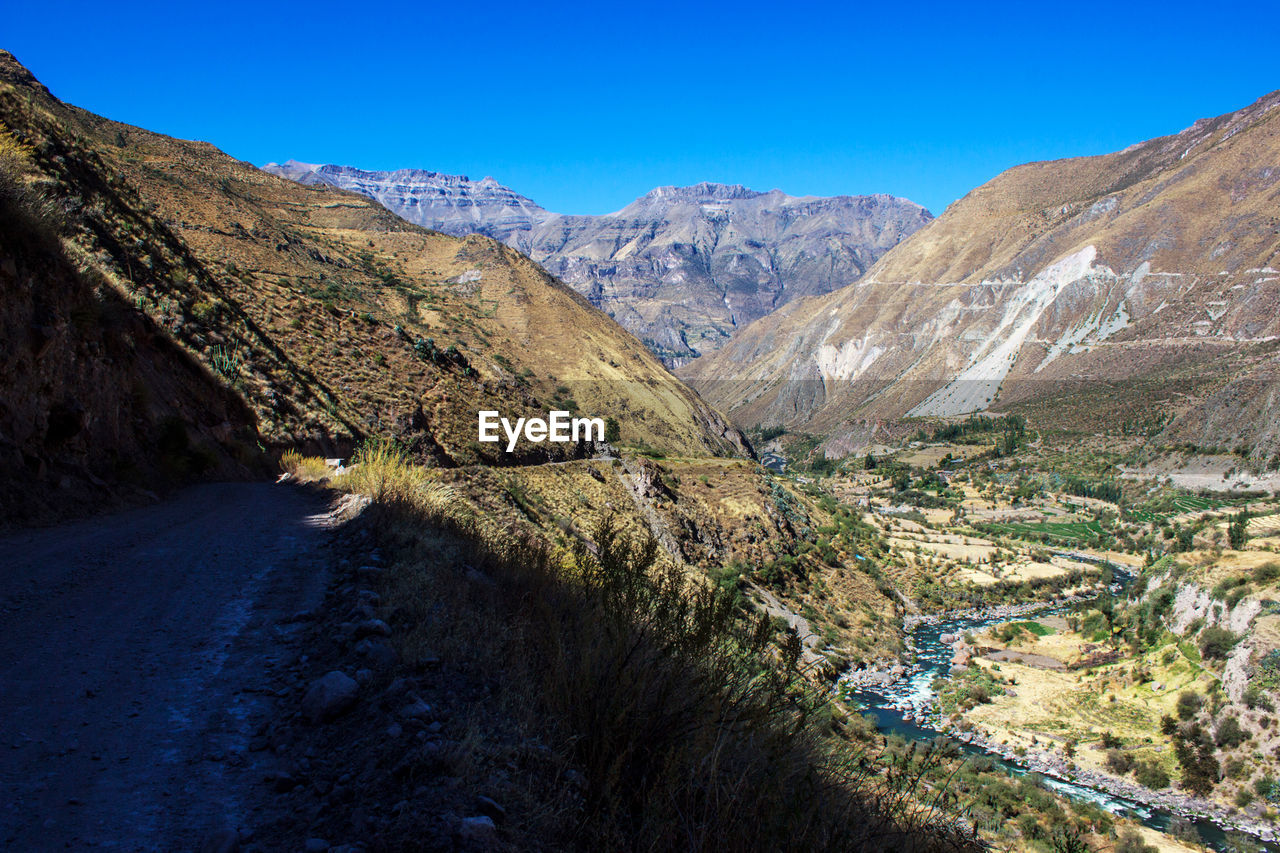 Scenic view of mountains against clear blue sky