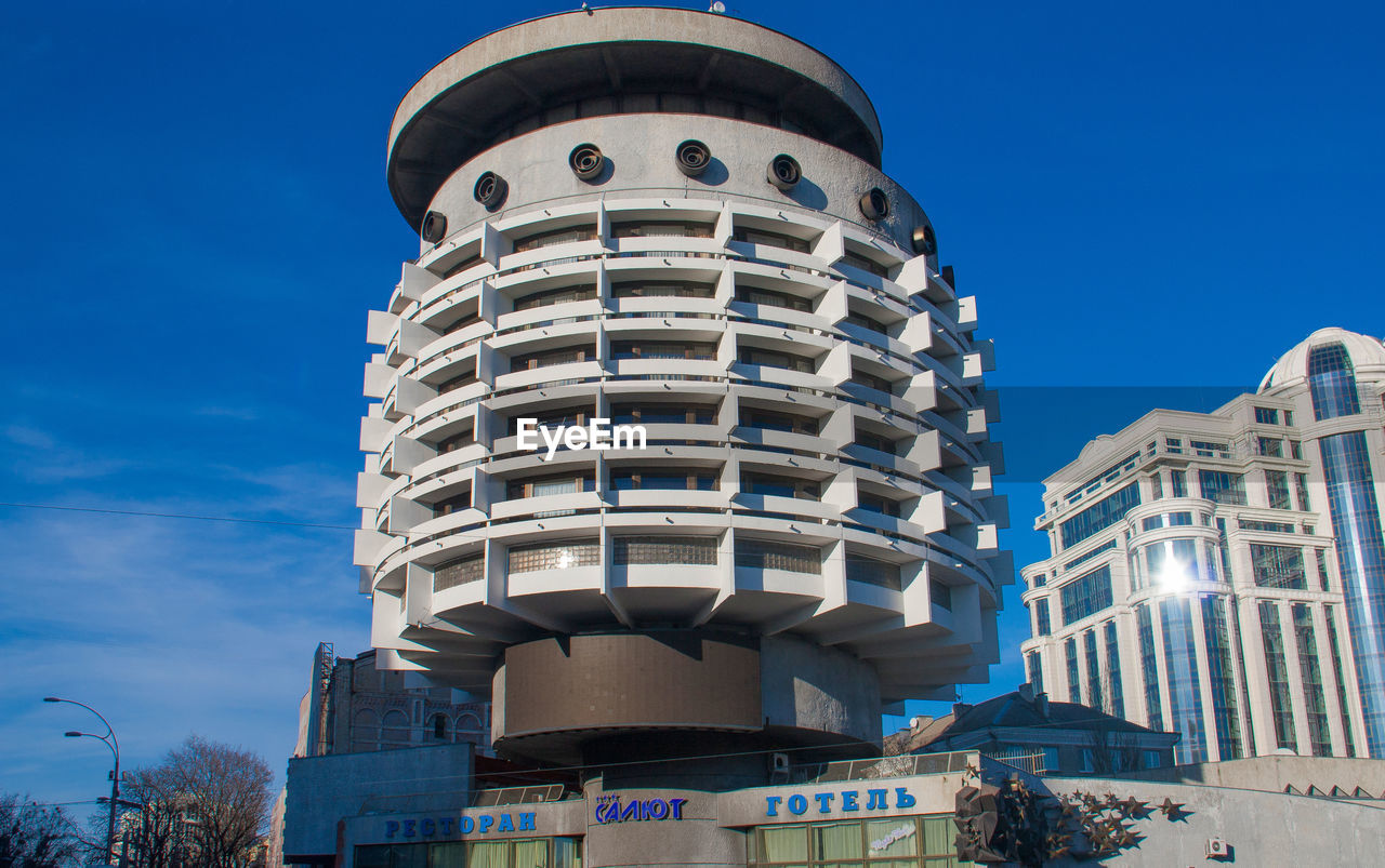 LOW ANGLE VIEW OF BUILDINGS IN CITY AGAINST BLUE SKY