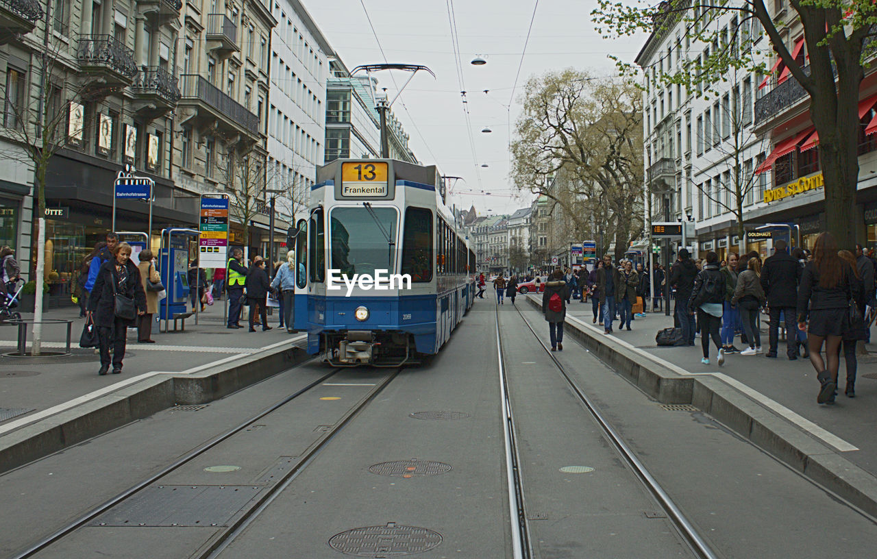 Tramway and people on street amidst buildings