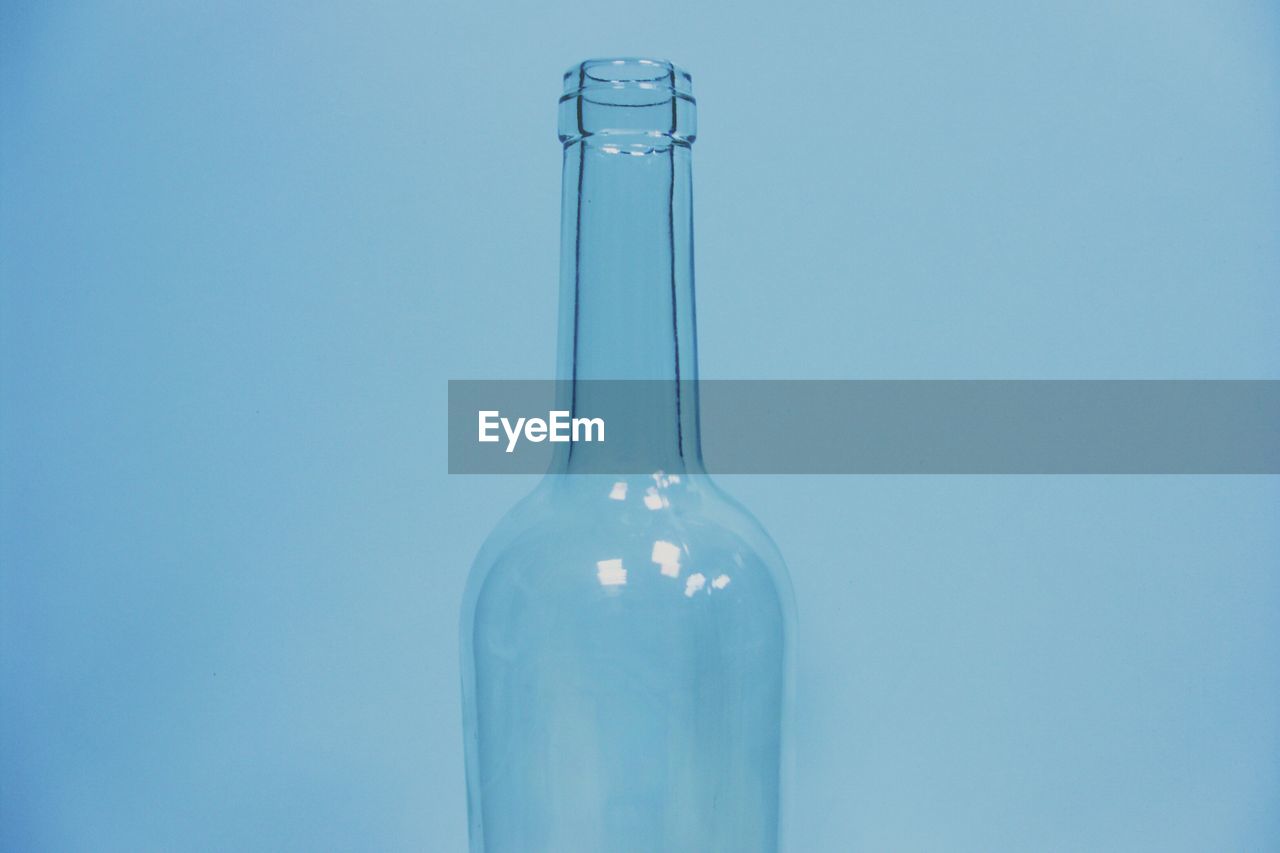 Close-up of empty bottle against blue background