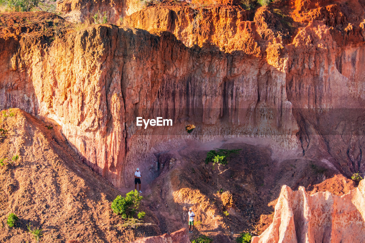 Tourists dwarfed by the rock formations at marafa depression - hell's kitchen at sunset in kenya