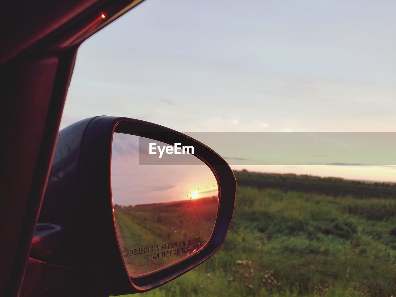 CLOSE-UP OF SIDE-VIEW MIRROR ON FIELD