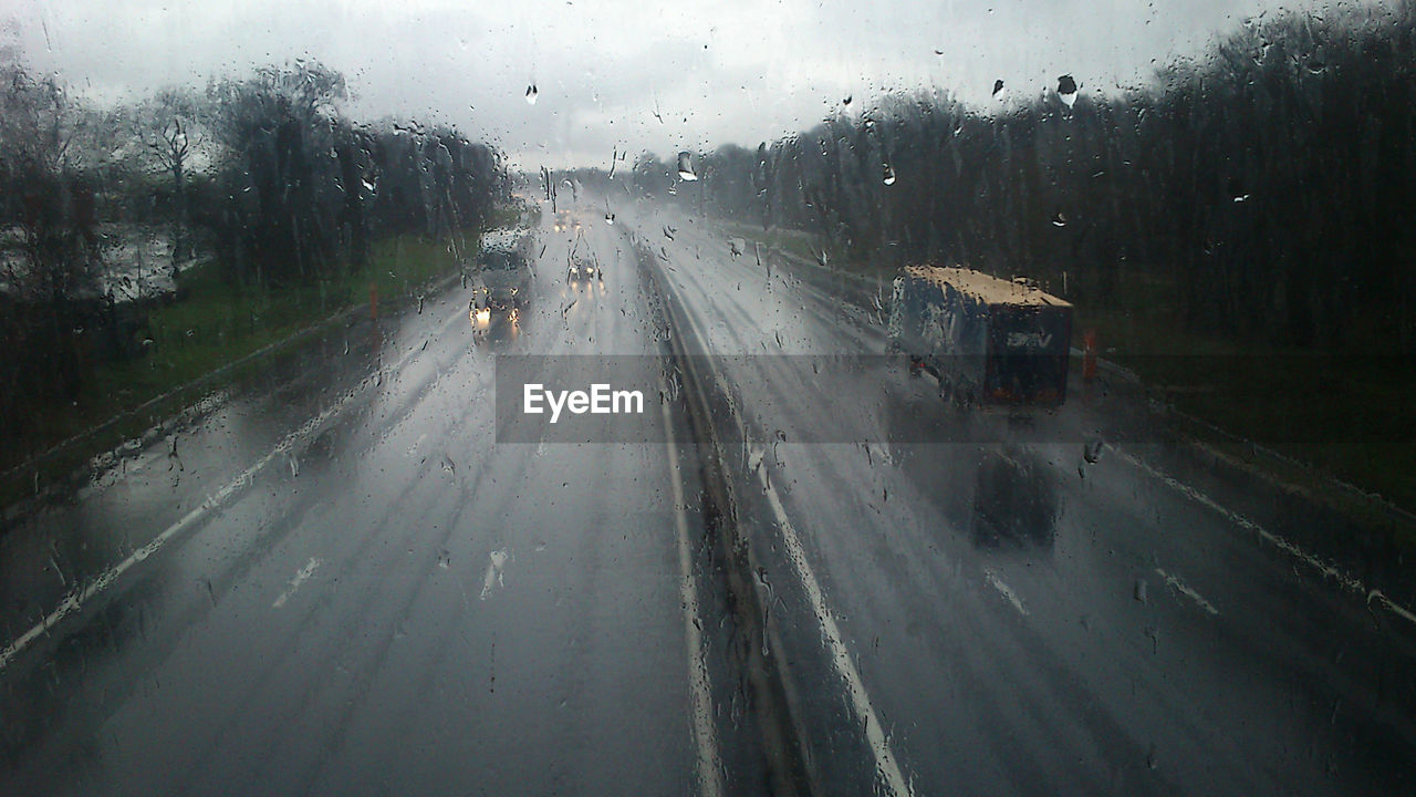 View of road seen through wet window