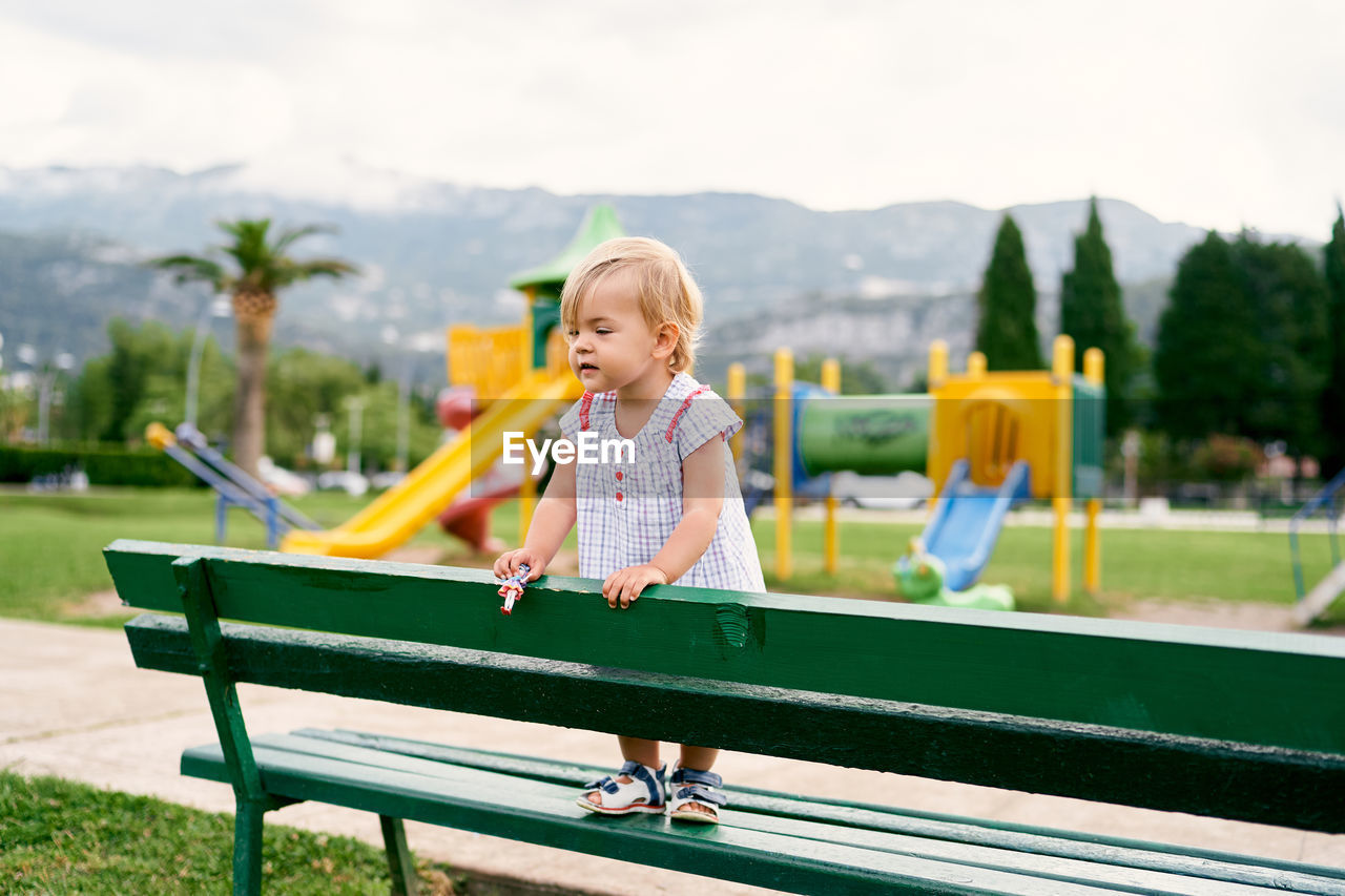 Full length of woman sitting on bench in park