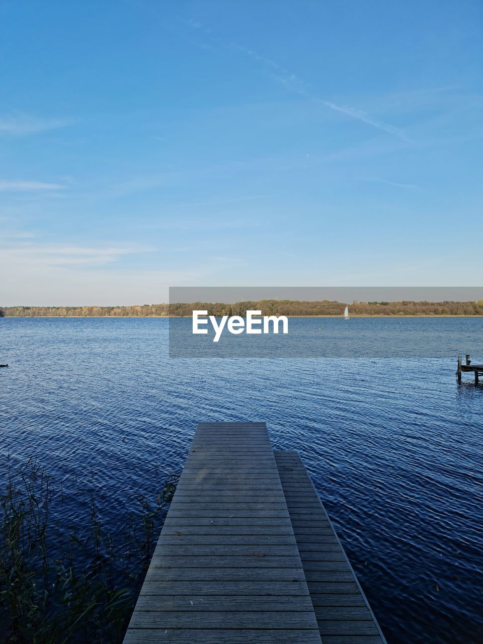 PIER AMIDST LAKE AGAINST BLUE SKY