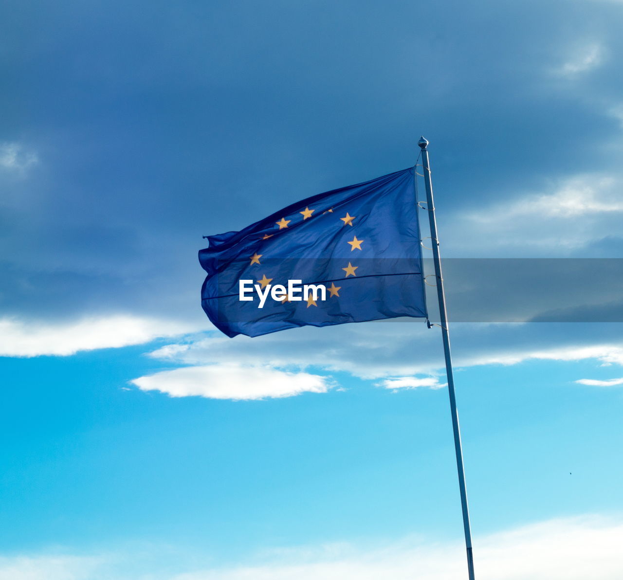 LOW ANGLE VIEW OF FLAG ON BLUE SKY