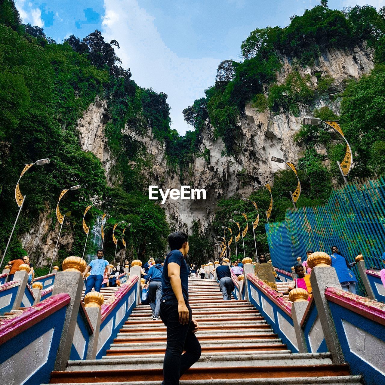 Side view of man standing on steps by mountains