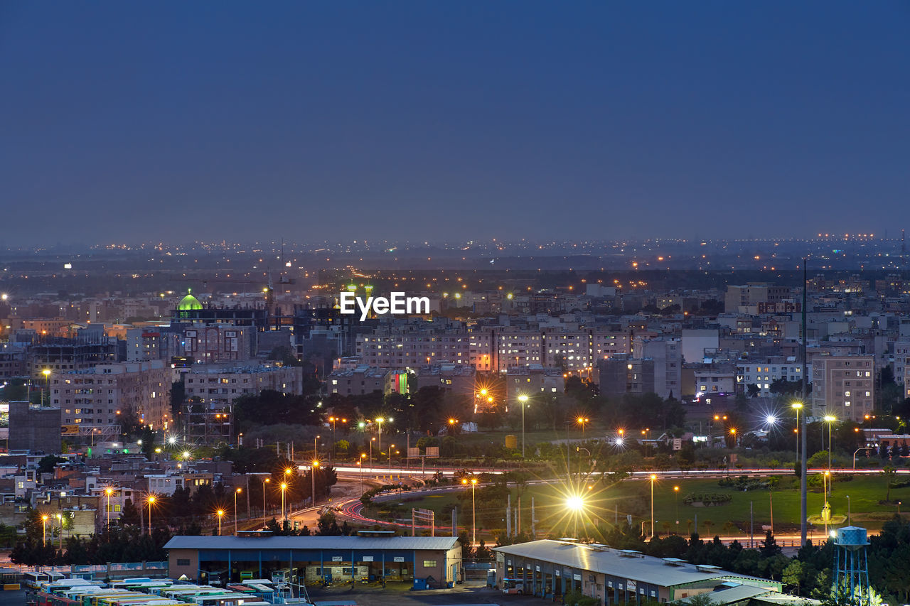 ILLUMINATED CITYSCAPE AGAINST CLEAR SKY AT NIGHT