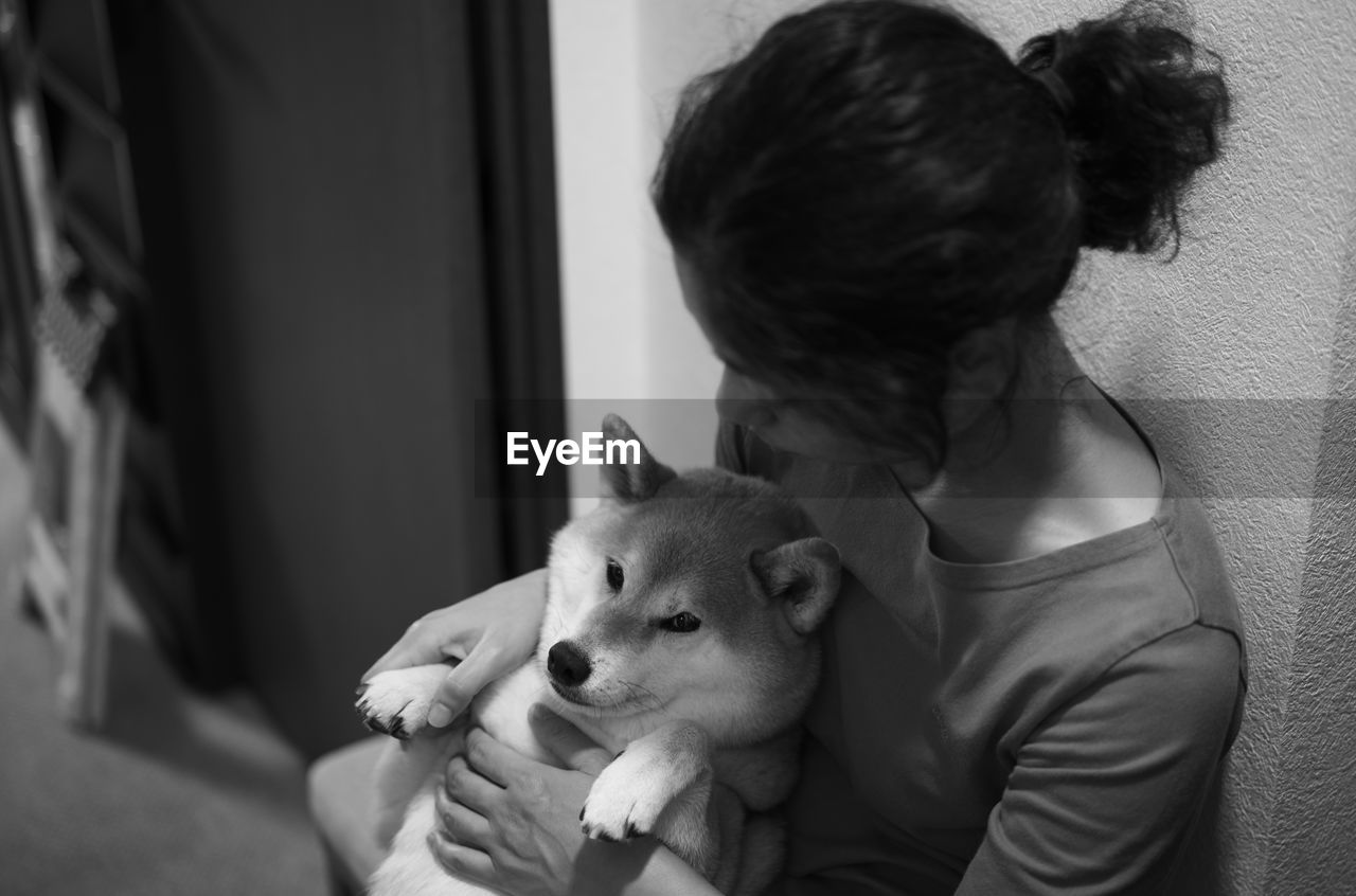 Close-up of woman with dog at home