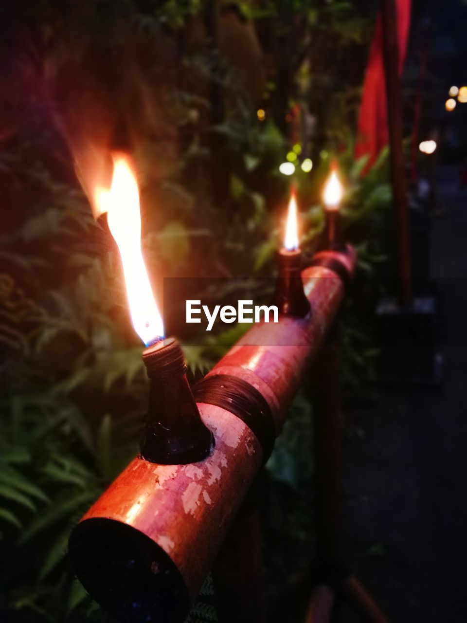 CLOSE-UP OF ILLUMINATED BURNING CANDLES