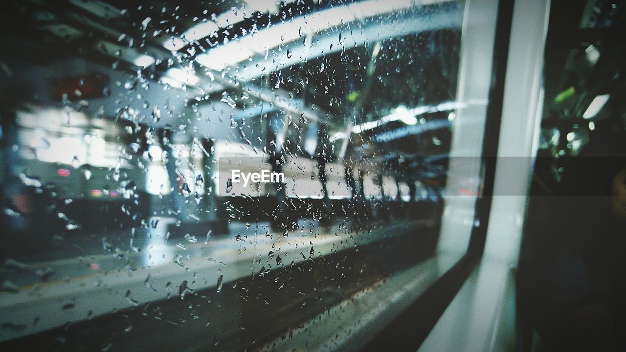 Railroad station platform seen from wet train window