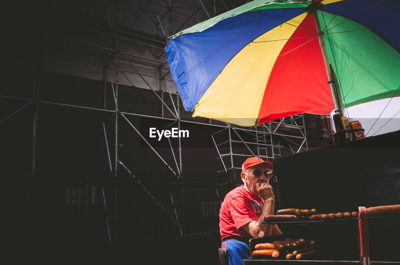 MAN SITTING ON UMBRELLA