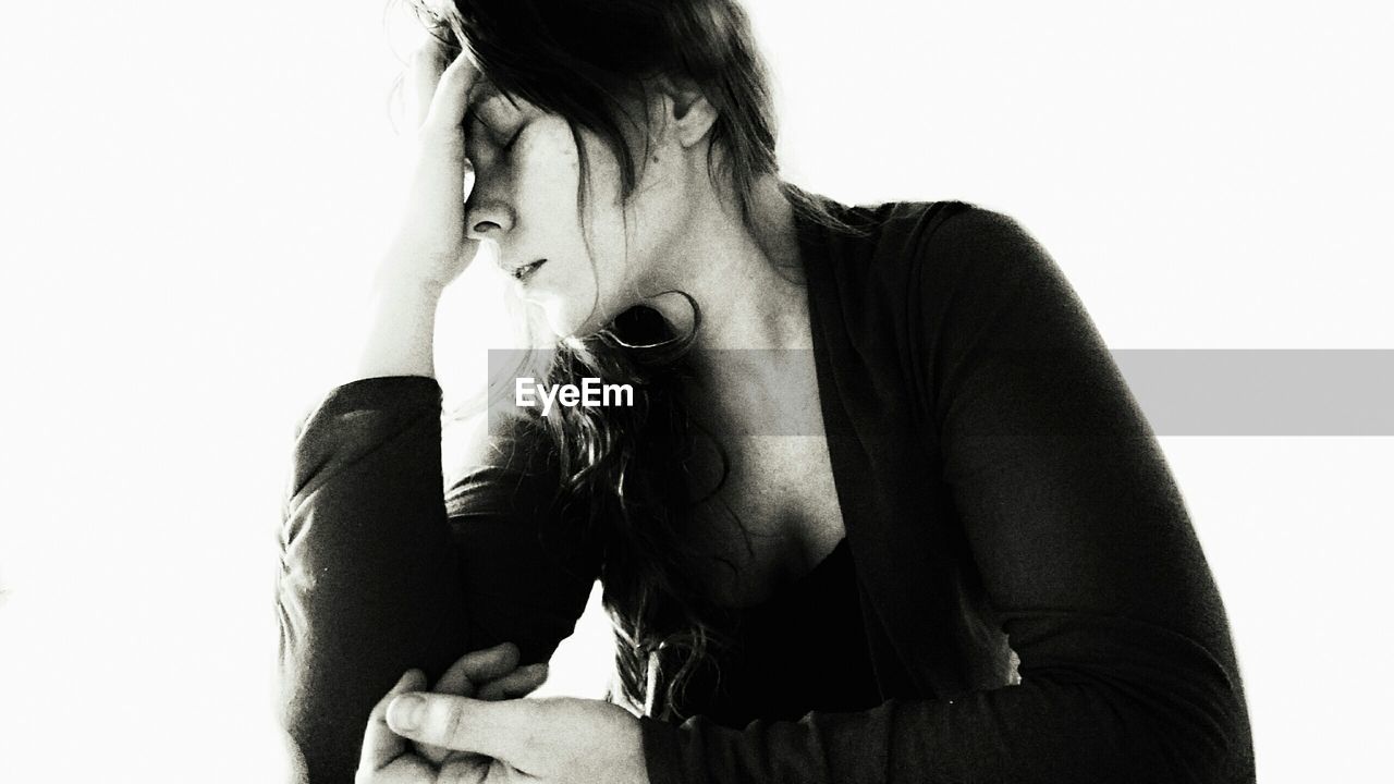 Close-up of depressed woman against white background