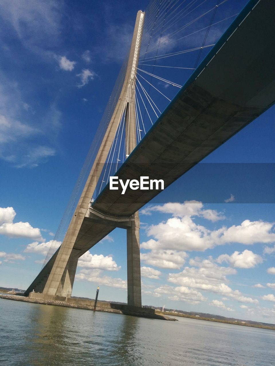 Low angle view of suspension bridge over river against sky