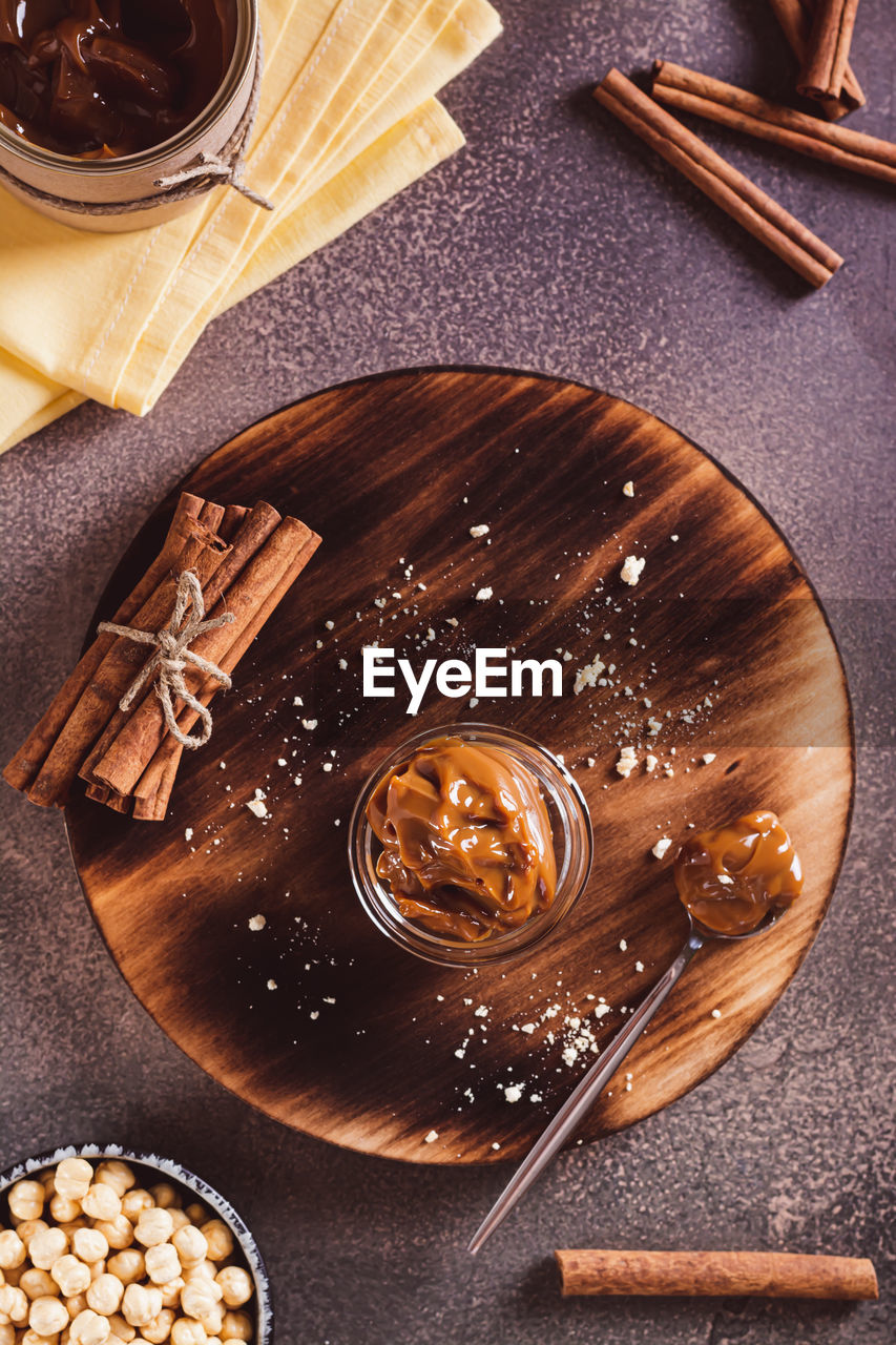 food and drink, food, high angle view, wood, sweet food, kitchen utensil, directly above, table, still life, indoors, eating utensil, freshness, spoon, no people, chocolate, drink, dessert, sweet, household equipment, baked, studio shot, cinnamon, refreshment, ingredient, spice, crockery, nut, sugar, healthy eating