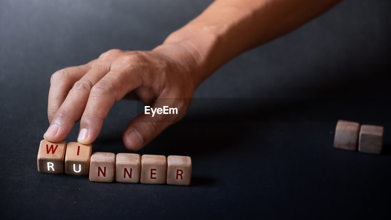 Hand holding dice with text for illustration of runner is winner words
