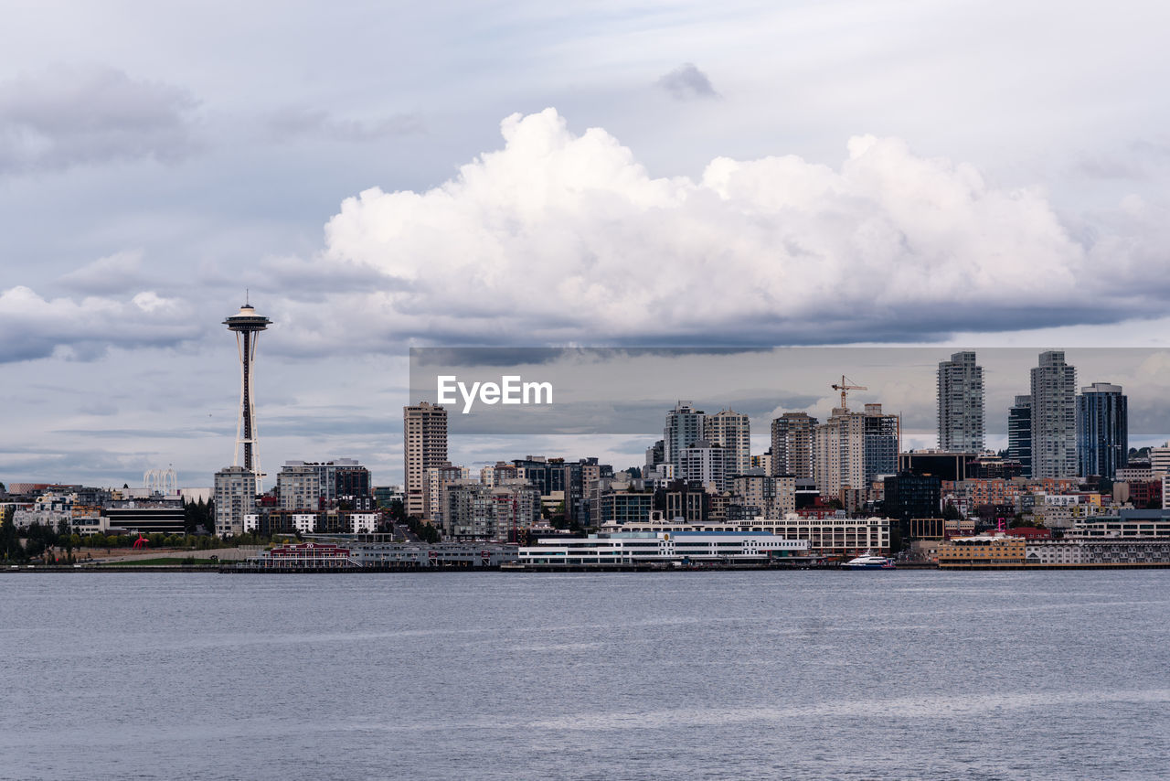 Buildings in city against cloudy sky