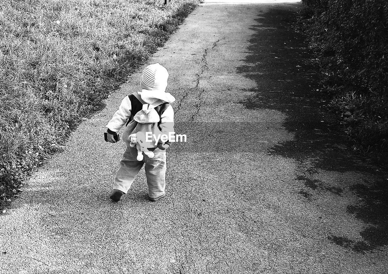 Little boy walking on footpath