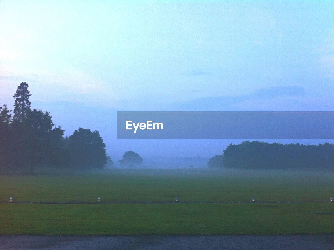 SCENIC VIEW OF GRASSY FIELD AGAINST SKY DURING SUNRISE