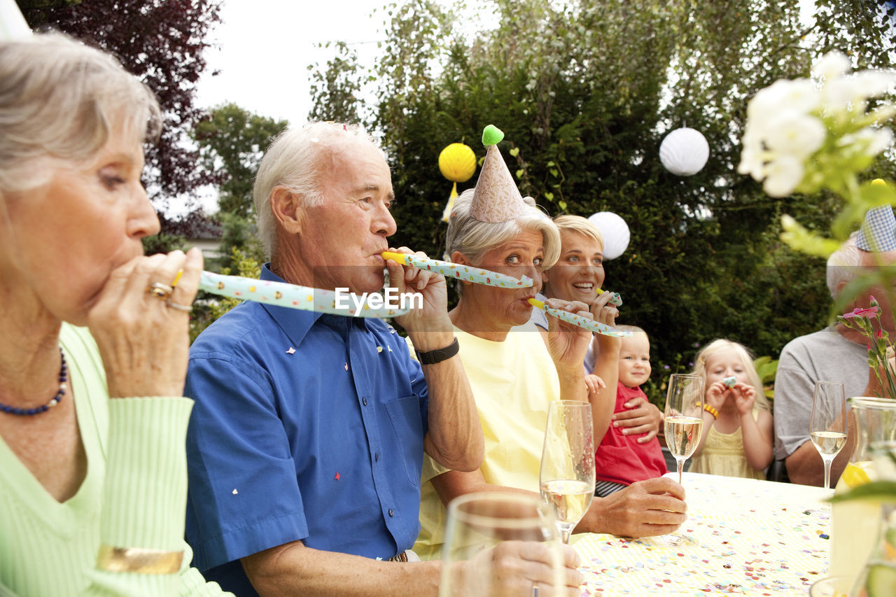 Extended family and friends having birthday party in garden